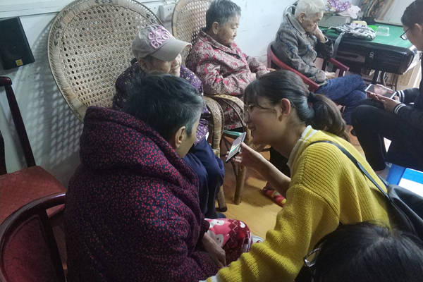 志愿者给老人播放戏曲