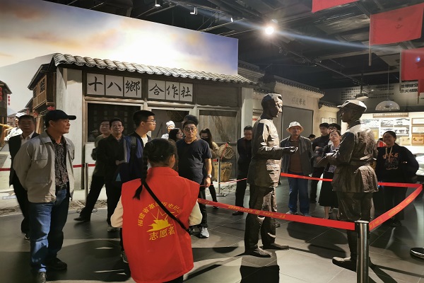 志愿讲解员向同学们介绍雕像还原的历史事件